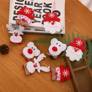 Christmas plush brooches featuring Santa and Reindeer on a cozy wooden background