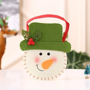 Detail van handgemaakte sneeuwpop vilten kerstcadeautas met groene hoed en rode handvaten
