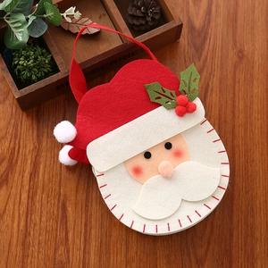 Gedetailleerde weergave van handgemaakte Kerstman vilten geschenktas met hulst decoratie