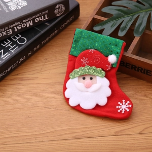 Détail d'une chaussette de Noël rouge avec paillettes, Père Noël et broderie blanche