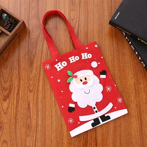 Close-up of red Christmas gift bag featuring Santa Claus embroidery and Ho Ho Ho text