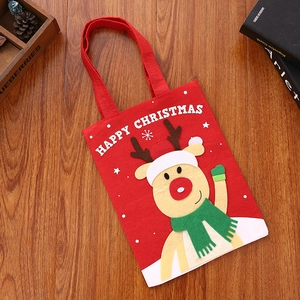 Detail of red Christmas gift bag with cartoon reindeer and Happy Christmas text