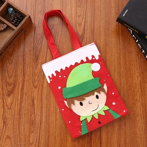 Detail of red felt Christmas gift bag featuring a cute cartoon elf on wood background