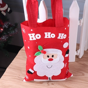 Detailed shot of red felt Christmas gift bag featuring Santa Claus and HO HO HO text