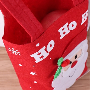 Detail of red Christmas felt gift bag featuring Santa Claus applique and HO HO HO slogan