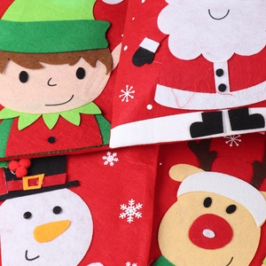 Detail of colorful thick felt Christmas gift bags with stitched cartoon holiday characters