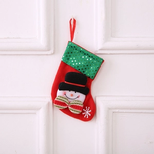 Chaussette de Noël avec motif bonhomme de neige et paillettes vertes sur porte blanche
