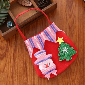 Detail of felt Christmas gift bag with cute snowman and tree on a rustic wooden background