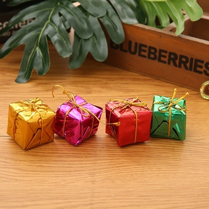 Colorful mini foil gift box ornaments for Christmas tree decoration on wooden background