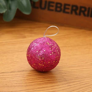 Close-up of rose red glitter Christmas ball with gold sequins and silver string hanging