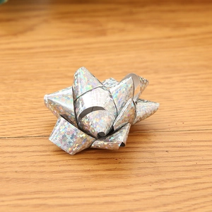 Detailed view of large silver holographic star bow for Christmas gift box decoration