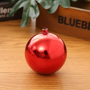 Polished red mirrored Christmas ball ornament hanging with a festive string