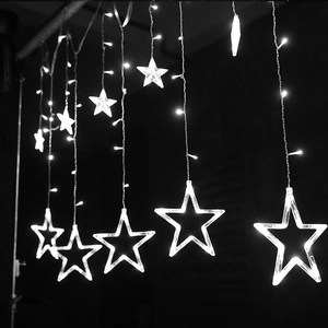 Close-up of LED star curtain lights with hanging glowing ornaments for Christmas
