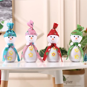 Set of four colorful plush snowman Christmas gift bags in red, pink, blue, and green colors