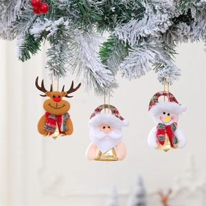 Close-up of plush Santa Reindeer and Snowman ornaments with bells on snowy branches