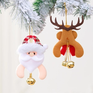 Close-up of Santa and reindeer Christmas tree ornaments with golden bells on snowy pine