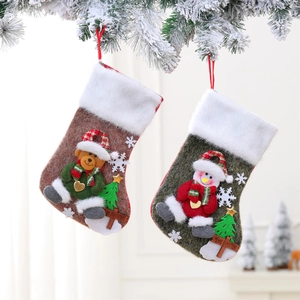 Large Christmas stockings with bear and snowman 3D characters on snowy pine background