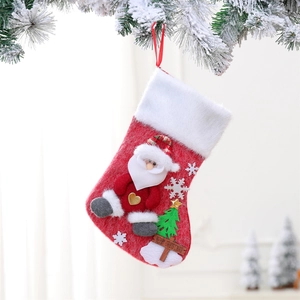 Detail of Christmas stocking with Santa applique and Merry Christmas wood tag on snowy branch