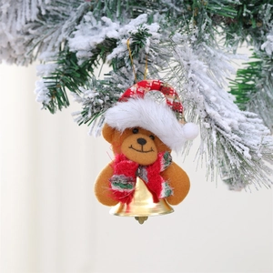 Detail of Christmas teddy bear ornament with a red hat and gold bell on a snowy pine branch