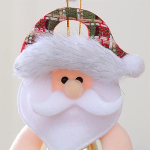 Macro detail of plush Santa hanging ornament with bell and red plaid fabric hat