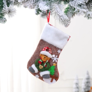 Detail of Christmas stocking with 3D teddy bear and Merry Christmas plaque on snowy branch