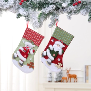 Detail of red and green knitted Christmas stockings with 3D dolls and wooden Merry Christmas tags