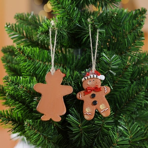 Detail of gingerbread man Christmas ornament with resin texture on a green pine branch