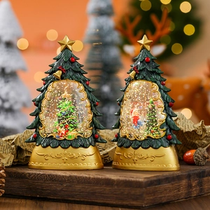 Two Christmas tree water globes with gold bases and festive sparkling glitter inside