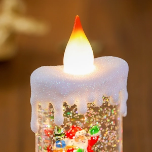 Dettaglio macro della candela LED di Natale con miniatura di Babbo Natale e glitter