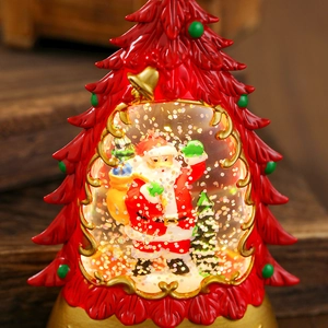 Macro shot of red Christmas tree snow globe lamp with Santa Claus and golden glitter
