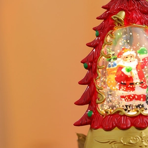Detail of red Christmas tree lantern with Santa Claus figurine and silver glitter inside