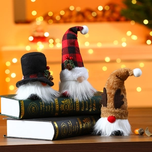 Three glowing Christmas gnomes with LED lights on books featuring cozy holiday bokeh background