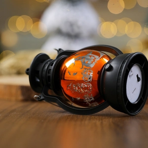 Detail of the vintage black frame, orange pumpkin lantern base, and bottom power switch