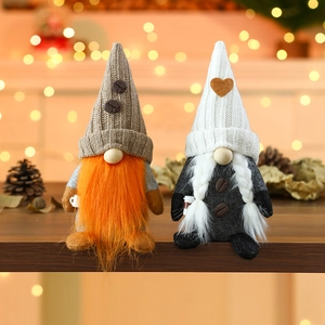 Pareja de gnomos de café de peluche con gorros de punto y granos de café sobre madera