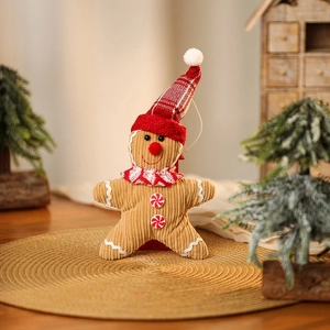 Close-up of plush gingerbread man ornament with knit hat and scarf on a festive table