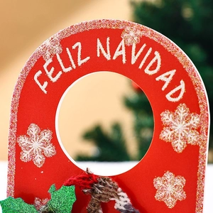 Close-up of red Christmas door hanger with Feliz Navidad text and glittery snowflakes