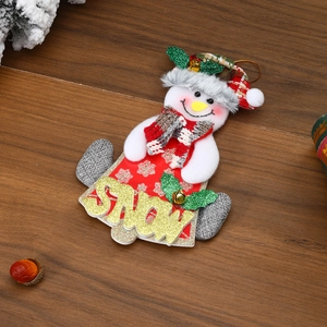 Detail view of a plush Snowman Christmas ornament with SNOW lettering and plaid hat