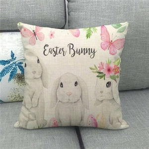 Detail of linen cushion cover with Easter Bunny print and floral texture on a gray sofa