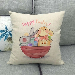 Close-up of linen Happy Easter pillowcase with rabbit and egg print on a grey sofa