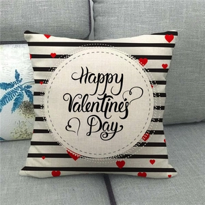 Détail de la housse de coussin en lin pour la Saint-Valentin sur un canapé gris