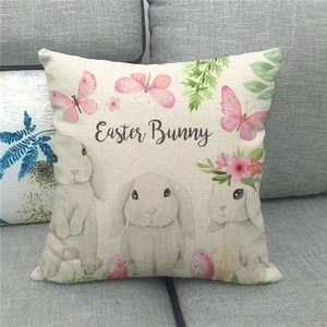 Close-up of linen Easter pillow cover with bunny floral print on grey sofa