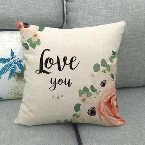 Détail de la taie d'oreiller en lin avec motifs floraux roses et lettrage Love You