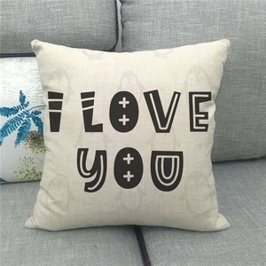 Détail de taie d'oreiller en lin avec texte I LOVE YOU sur canapé gris pour la Saint-Valentin