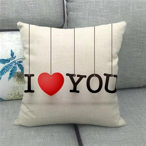 Vue détaillée d'une housse de coussin en lin avec imprimé cœur sur un canapé gris