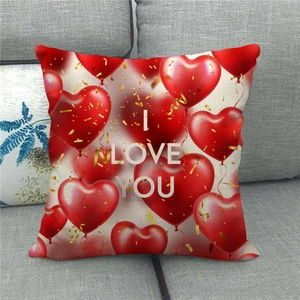 Detail of linen pillowcase with red heart balloons and I LOVE YOU text on gray sofa