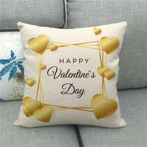 Linen Valentine's Day pillow cover with golden heart and text on a grey fabric sofa