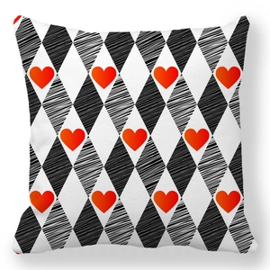 Detail of peach skin fabric square pillowcase with red hearts and black diamond patterns