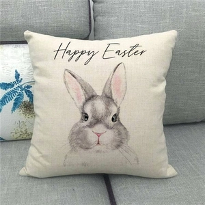 Detail eines Leinen-Kissenbezugs zu Ostern mit handgemaltem Hasen auf einem Sofa