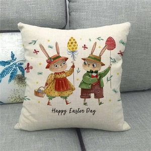 Detail eines Leinen-Osterkissenbezugs mit Hasen und Eiern auf grauem Sofa