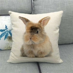 Nahaufnahme vom Oster-Leinenkissen mit Hasenmotiv auf grauem Stoffsofa
